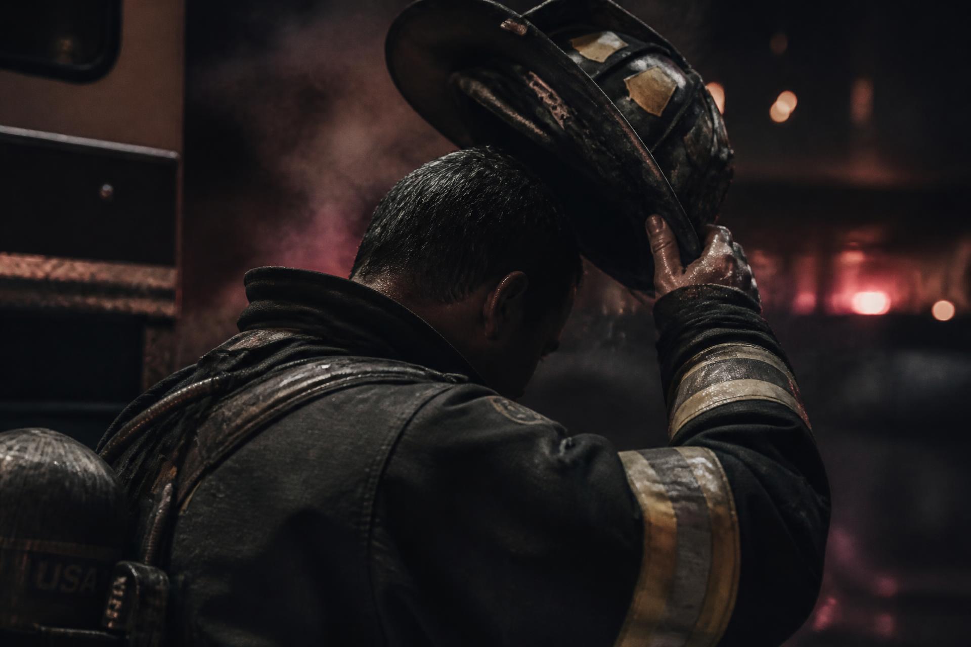 A firefighter removing his helmet after a call